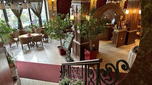 Un hall d’hôtel avec un escalier, un espace salon et un comptoir d’accueil.