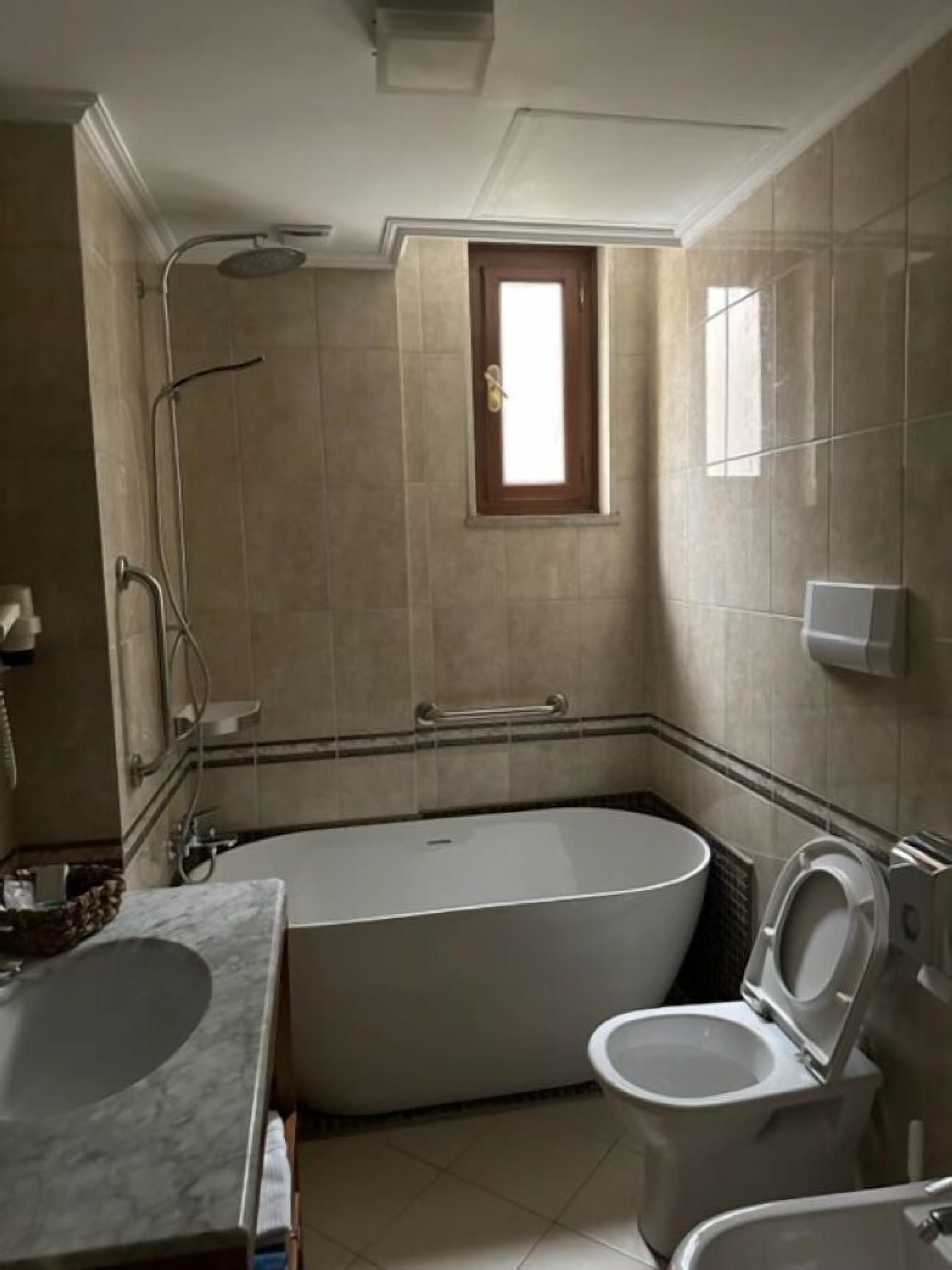 A bathroom with a bathtub, toilet, and sink.