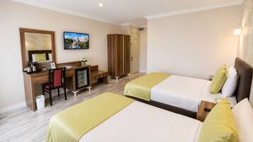 A hotel room with two beds, a desk, a chair, a television, and a wardrobe.