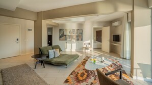 A modern living room with a green sofa, a coffee table, and a patterned rug. - Med-Inn Hotel (Milas)