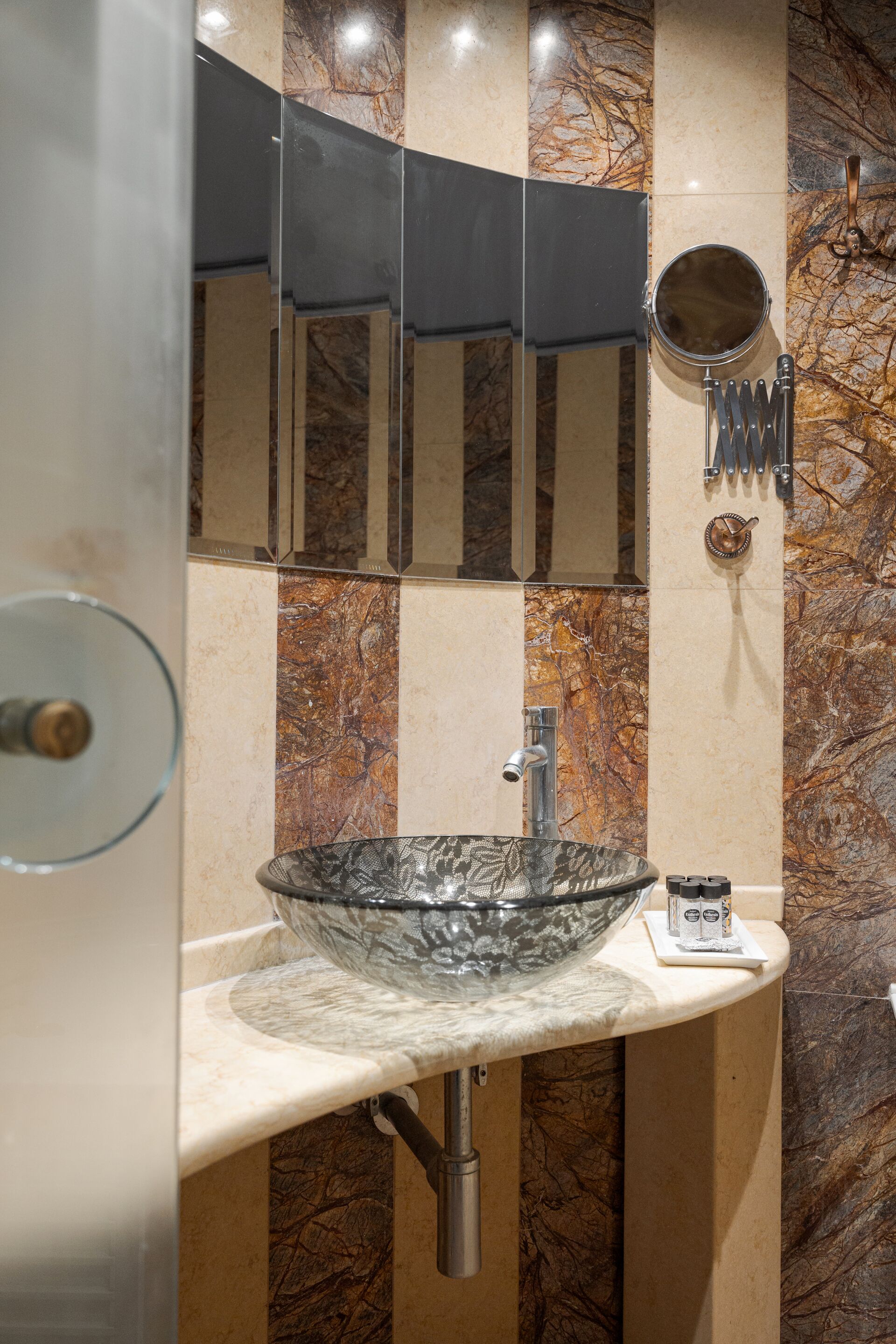Une salle de bain avec un lavabo en verre, un miroir et un porte-serviettes.