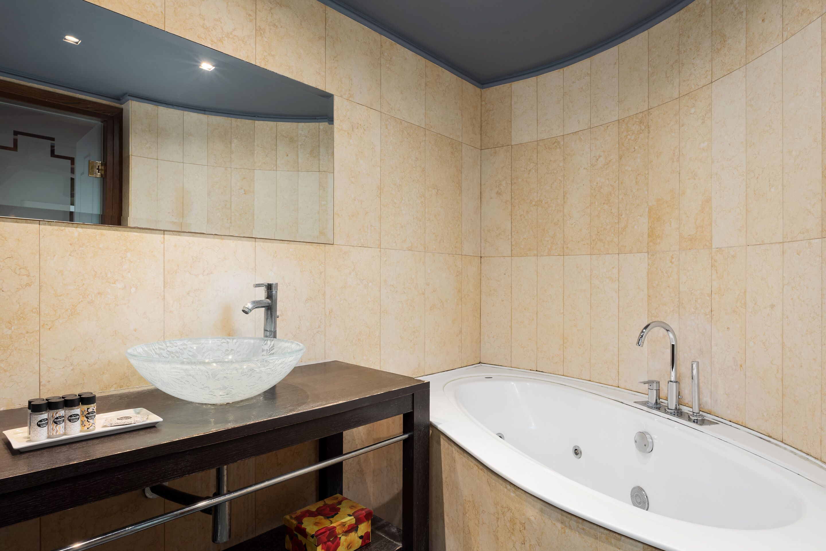 Une salle de bain moderne avec un grand lavabo en forme de bol en verre, une baignoire sur pieds et un miroir au-dessus du lavabo.