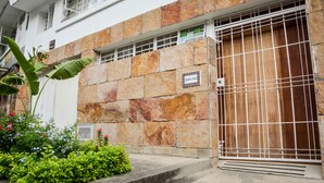 A building with a stone facade, a gated entrance, and a sign indicating "Jardin Azal". - Jardin Azul - Casa Hotel (Cali)