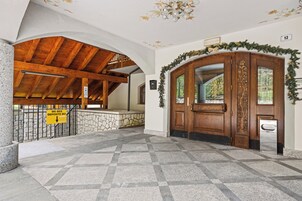 Un vestíbulo con piso a cuadros, techo de madera y pared de piedra.