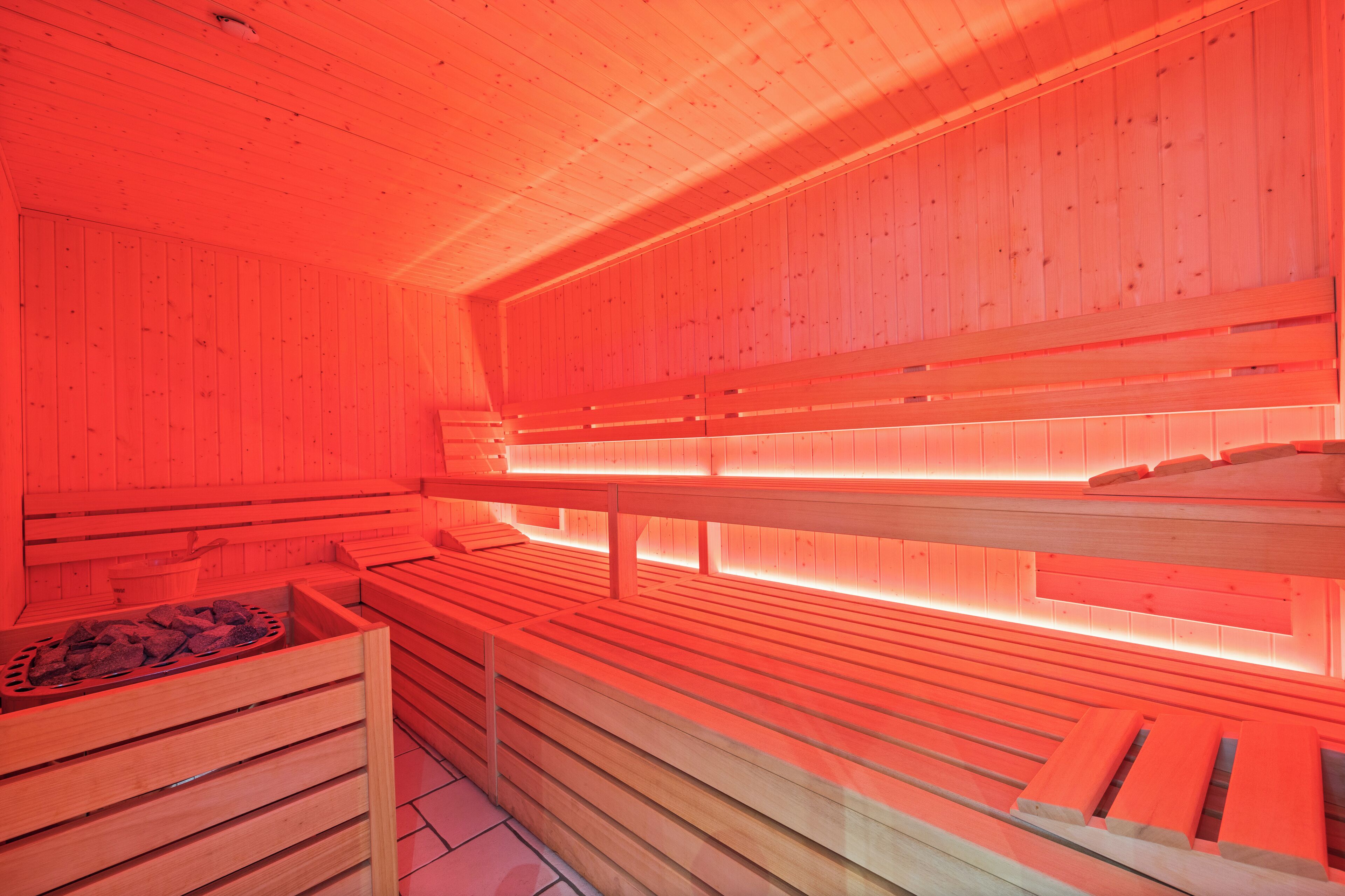 Eine Sauna mit Holzbänken und einer Steinschaukel.