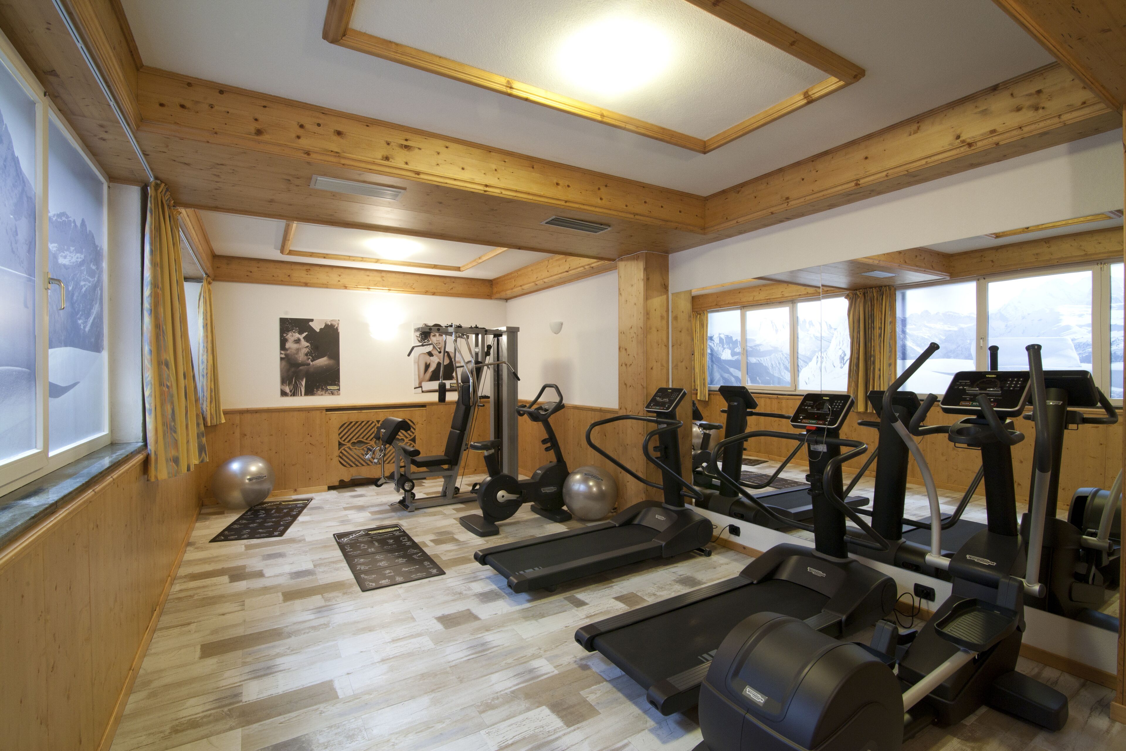 A gym with treadmills, elliptical machines, and exercise balls.