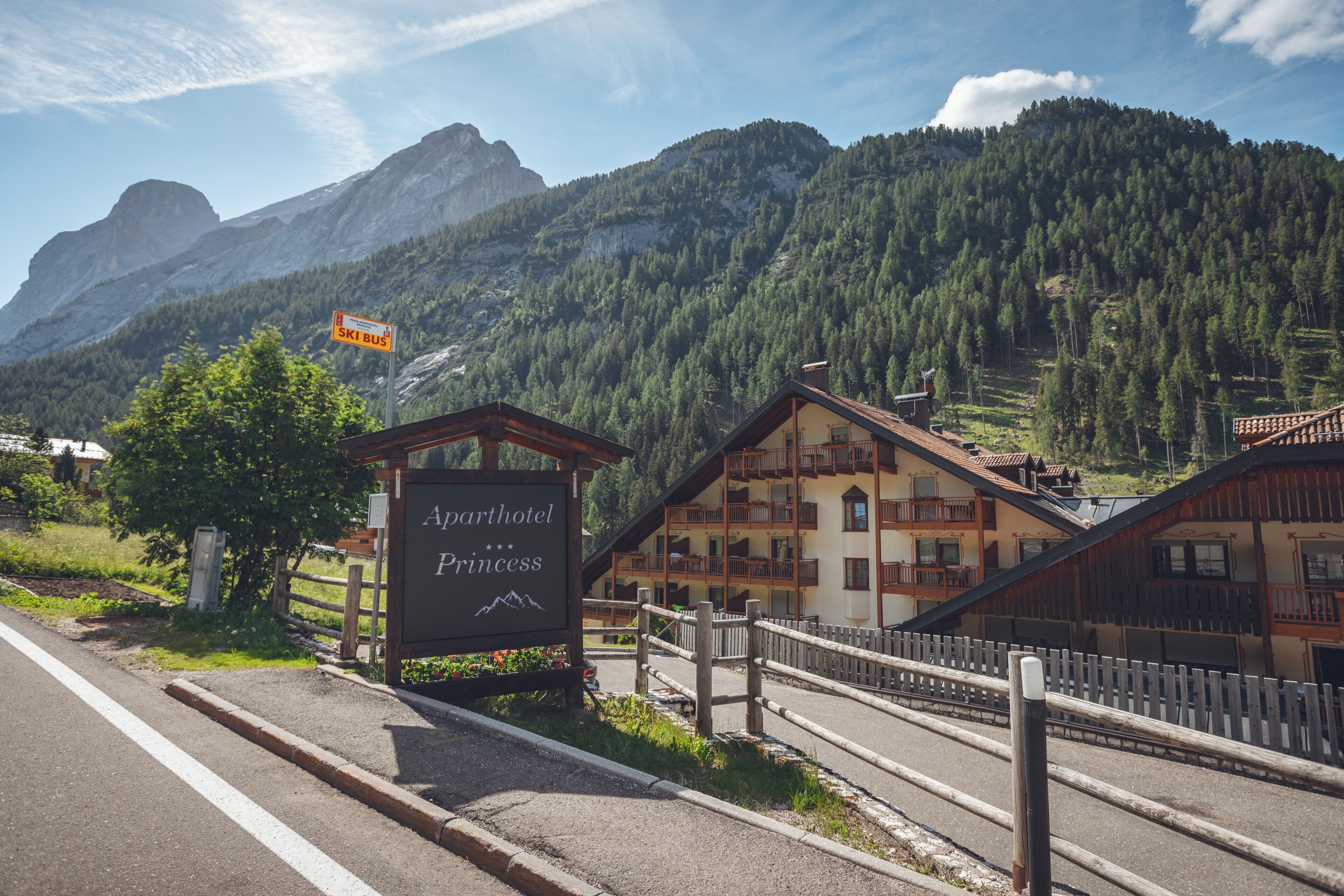 A sign for the 'Aparthotel Princess' with a mountain backdrop.