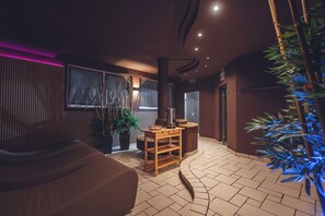 A modern interior with a curved wall, a seating area, and a visible door leading to another room. - Aparthotel Princess (Canazei)