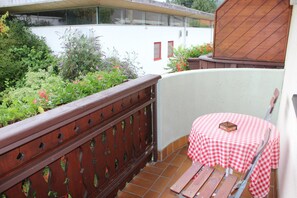 A small outdoor seating area with a checkered tablecloth and wooden benches. - Gasthof Pension Bürger (Schiefling am See)