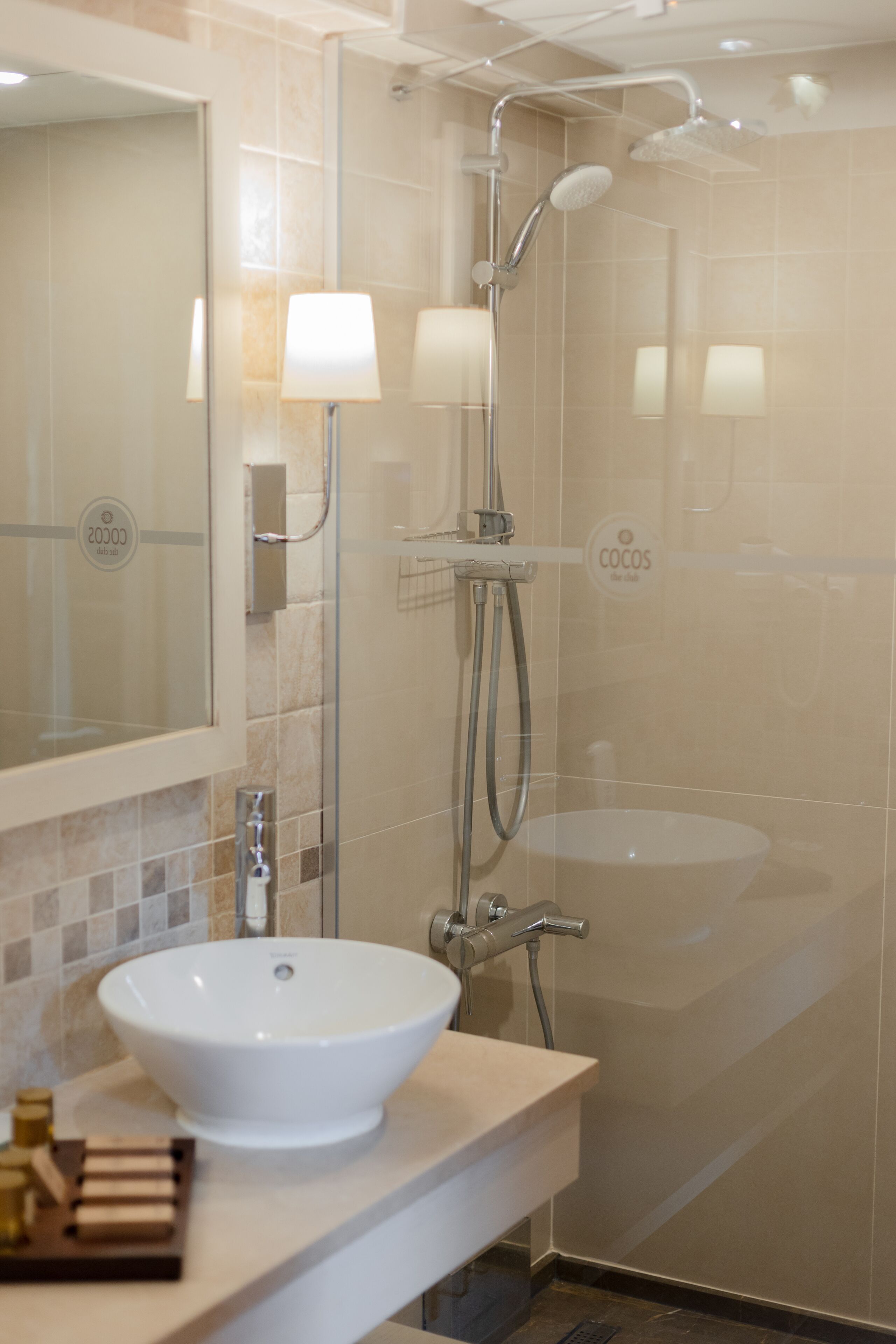 Un bany modern amb un mirall gran, un lavabo blanc, una dutxa amb plat de roba i un suport per a tovalloles.