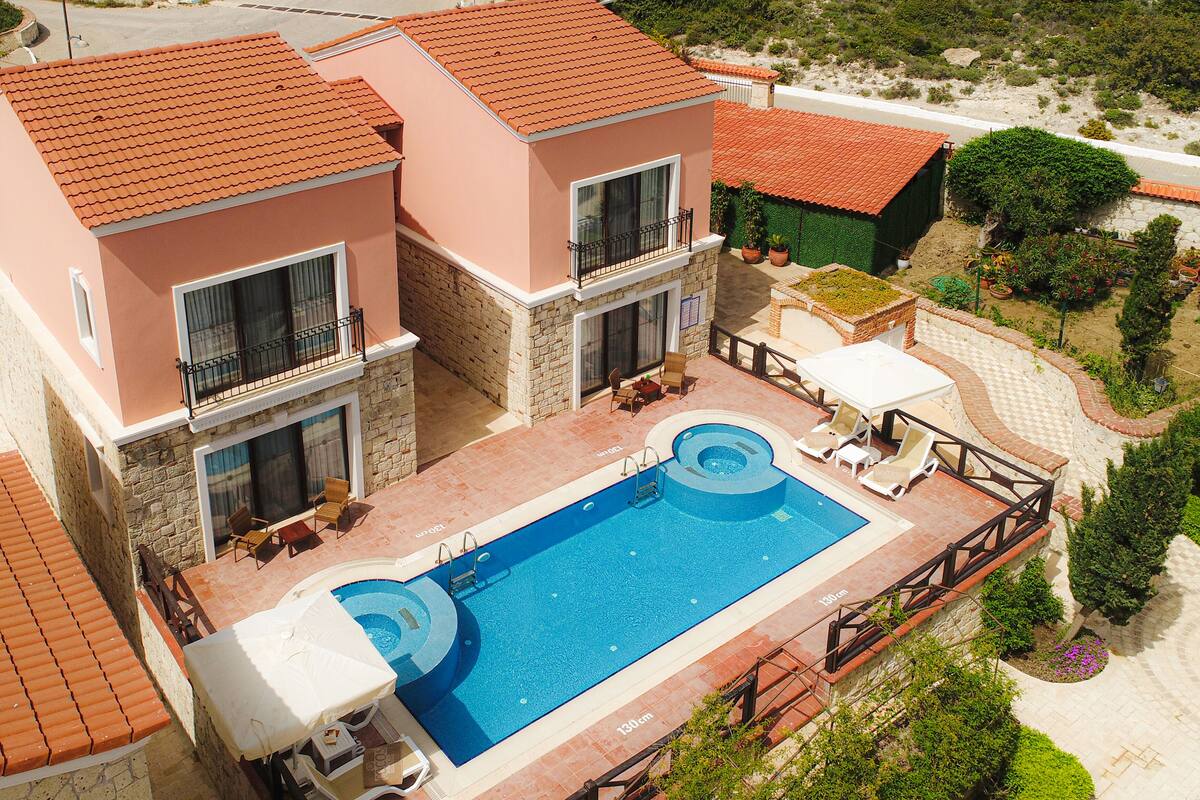 Un bâtiment à deux étages doté d’une piscine, d’un espace extérieur aménagé et offrant une vue sur le paysage environnant.