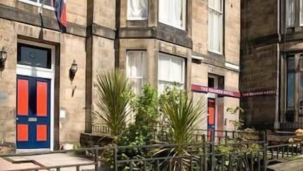 A building with a red and blue door, a flag, and a sign for 'The Charing Hotel'. - The Guards Hotel (Edinburgh)