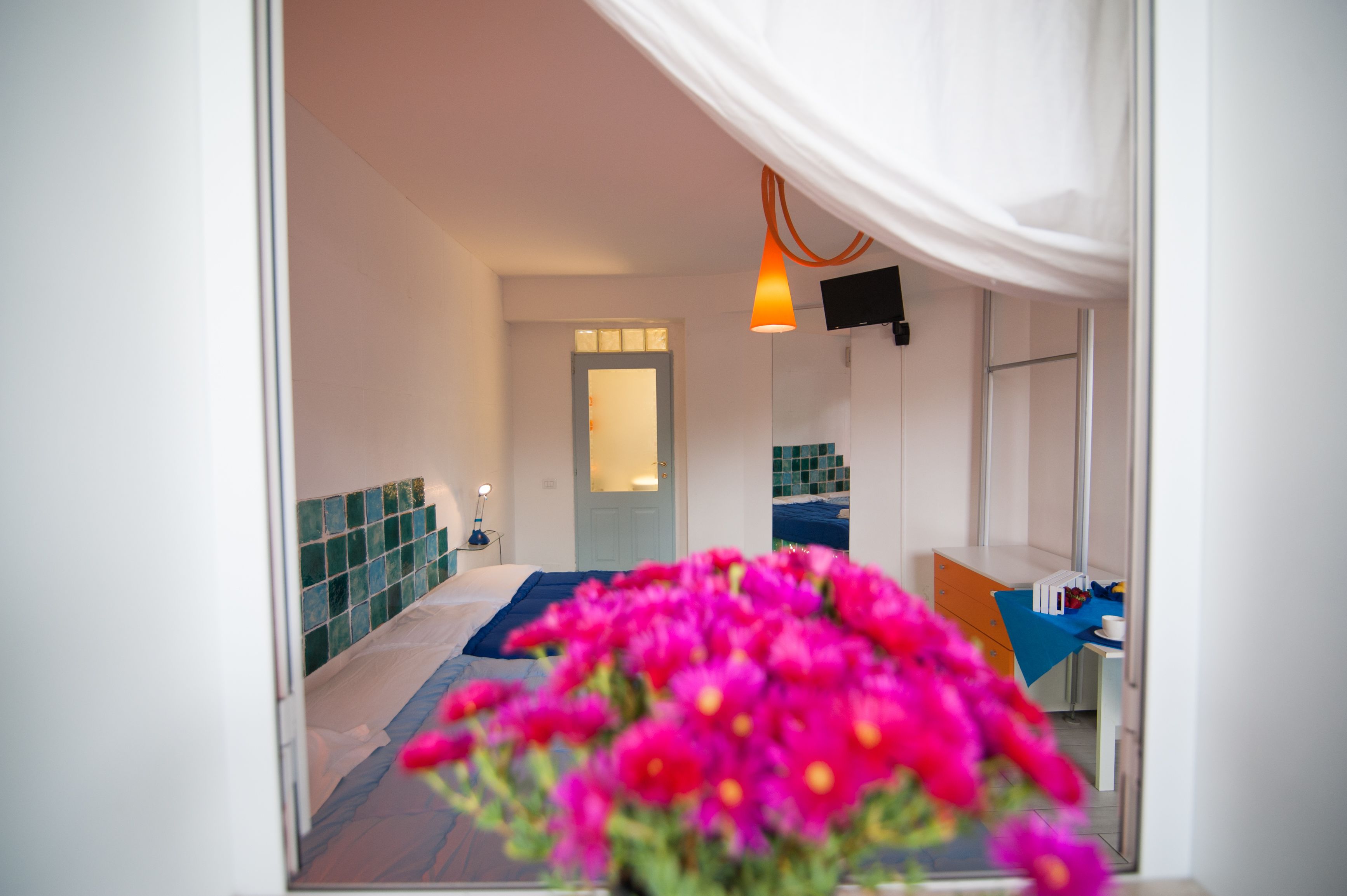 Una habitación de hotel con una cama, un escritorio, una silla, un televisor y una ventana.