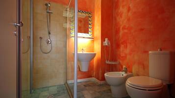 Baño con ducha, lavabo, inodoro y espejo con detalles de azulejos geométricos.