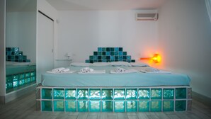 A modern bedroom with a bed, a nightstand, and a wall-mounted air conditioner. - Suite House L'isola che non c'è (Syracuse)