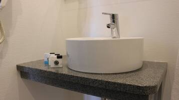 A bathroom with a white sink, a mirror, and a granite countertop.