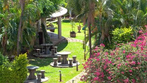 A garden with a gazebo, outdoor seating, and a variety of plants and flowers. - Hotel Foz do Iguaçu (Foz do Iguaçu)
