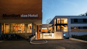 Ein modernes Hotel mit einem markanten Eingang, einer Treppe und einem Fahrradstellplatz.