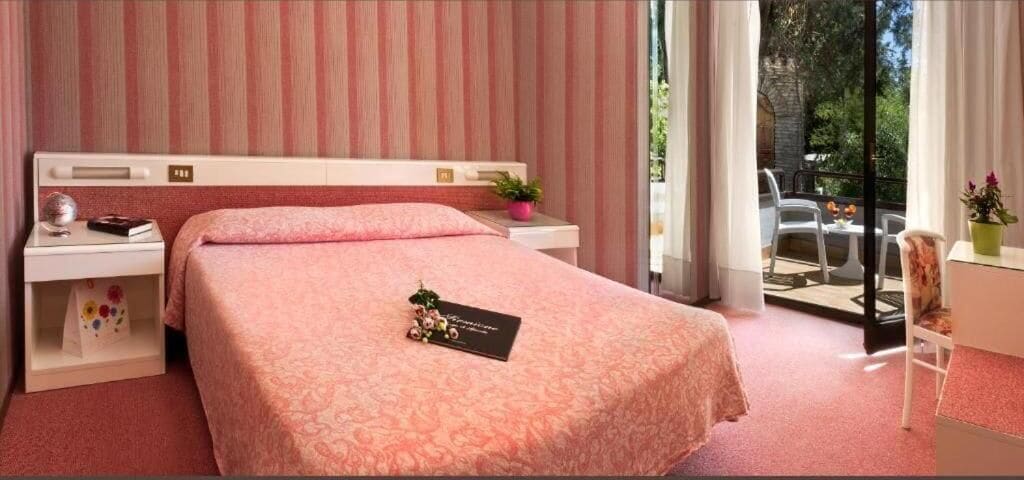 Een slaapkamer met een bed, nachtkastje en uitzicht op de omgeving.