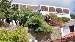 Un edificio de fachada de piedra, con varios balcones y un cartel que indica que es un hotel.