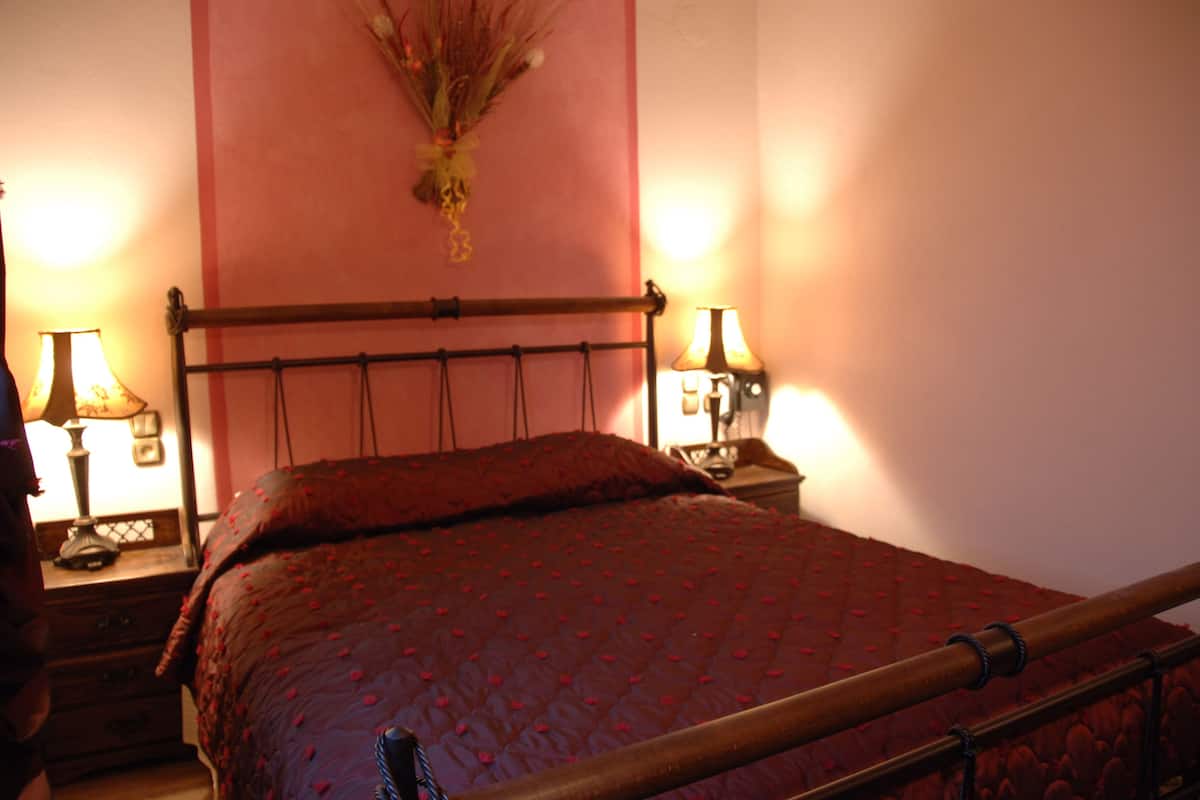 Ein Bett mit Kopfteil, zwei Nachttische mit Lampen und einer Wanddekoration.