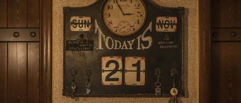 A wall-mounted clock with a rustic design, displaying the date as November 21.