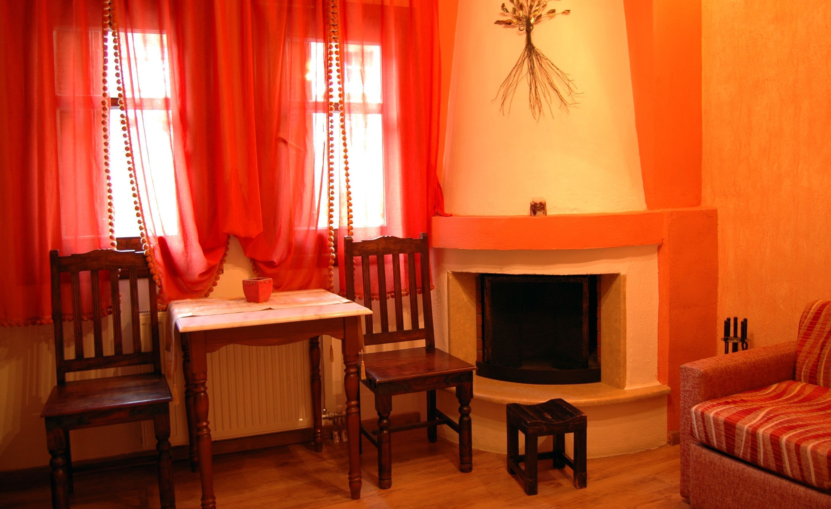 A cozy living room with a fireplace, a dining table with chairs, and a sofa.