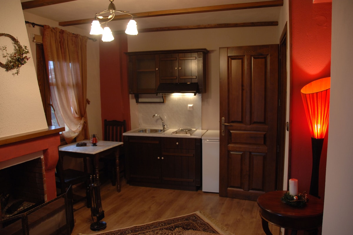 A compact kitchen with wooden cabinets, a sink, and a small dining table.