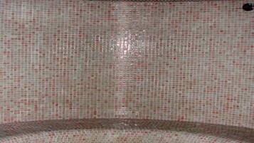 Relax in a spacious hot tub surrounded by a decorative tile pattern.