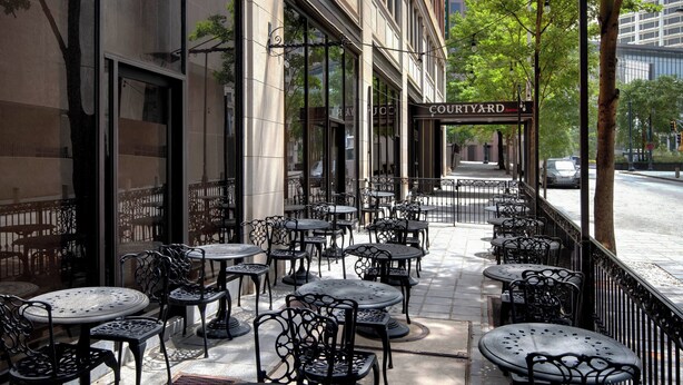 An outdoor cafe with tables and chairs, a sign reading "COUTURE," and a street view in the background. - Courtyard by Marriott Atlanta Downtown (Atlanta)