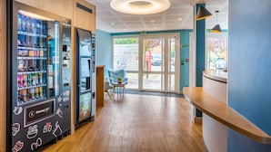 A modern interior with a vending machine, a reception desk, and a seating area. - Appart'City Confort St Quentin en Yvelines - Bois d'Arcy (Bois-d'Arcy)