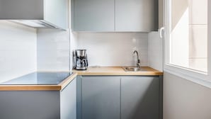 A compact kitchen with a coffee maker, sink, and cabinets. - Appart'City Confort St Quentin en Yvelines - Bois d'Arcy (Bois-d'Arcy)