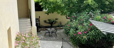 A courtyard with a potted plant, a small table, and a staircase.