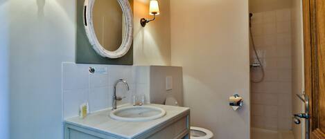 A bathroom with a sink, mirror, and toilet.