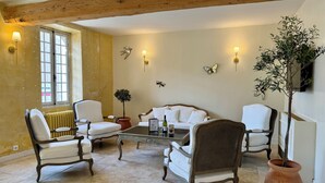 A cozy room with a wooden ceiling, white furniture, and decorative wall lights. - Hôtel du Midi (Visan)