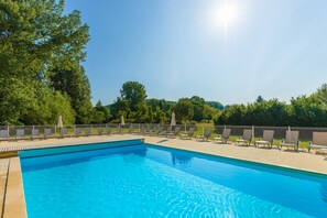 Relax by the pool surrounded by lush greenery and lounge in style.