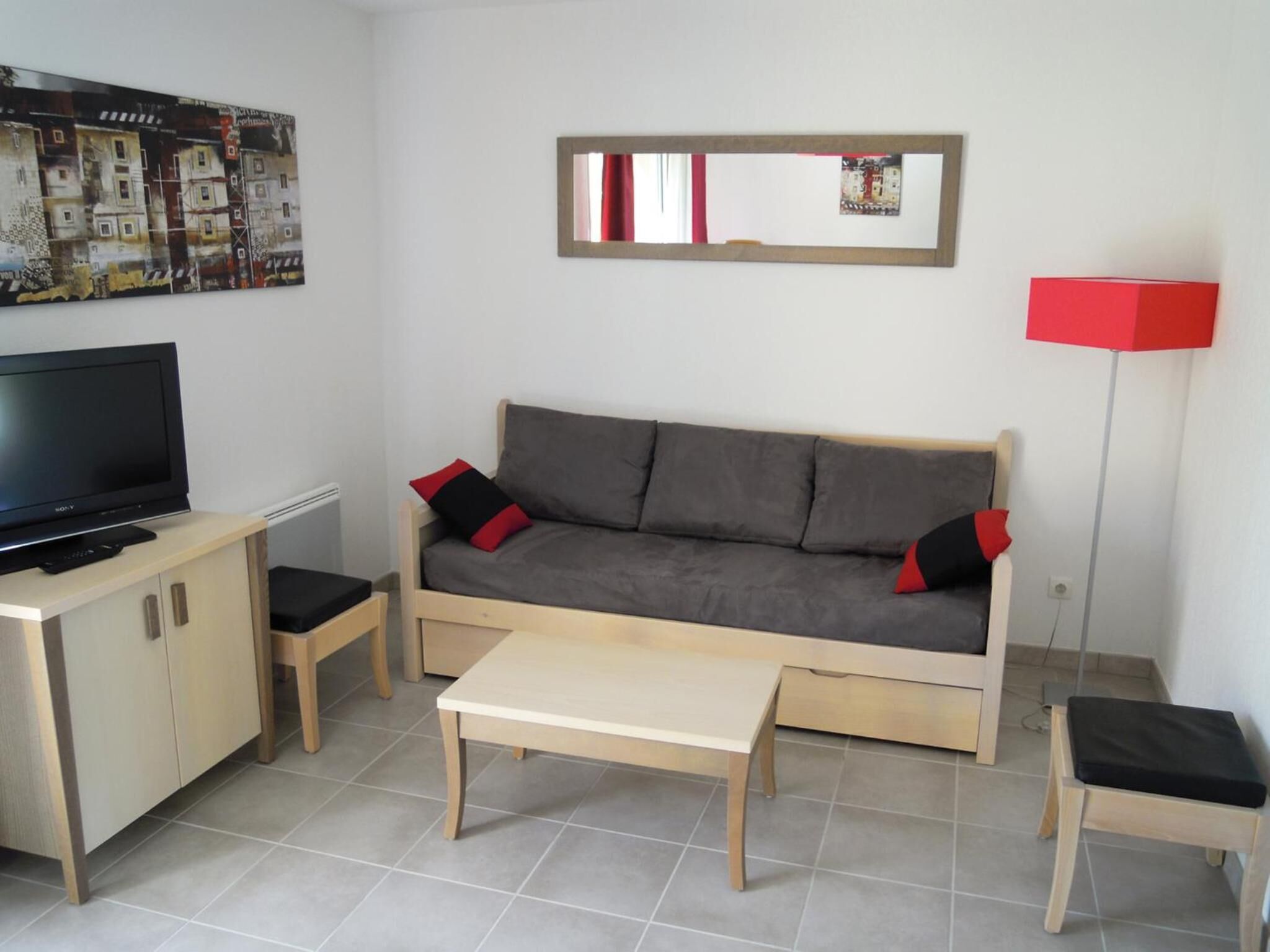 A compact living space with a sofa, a TV, a coffee table, and a cabinet.