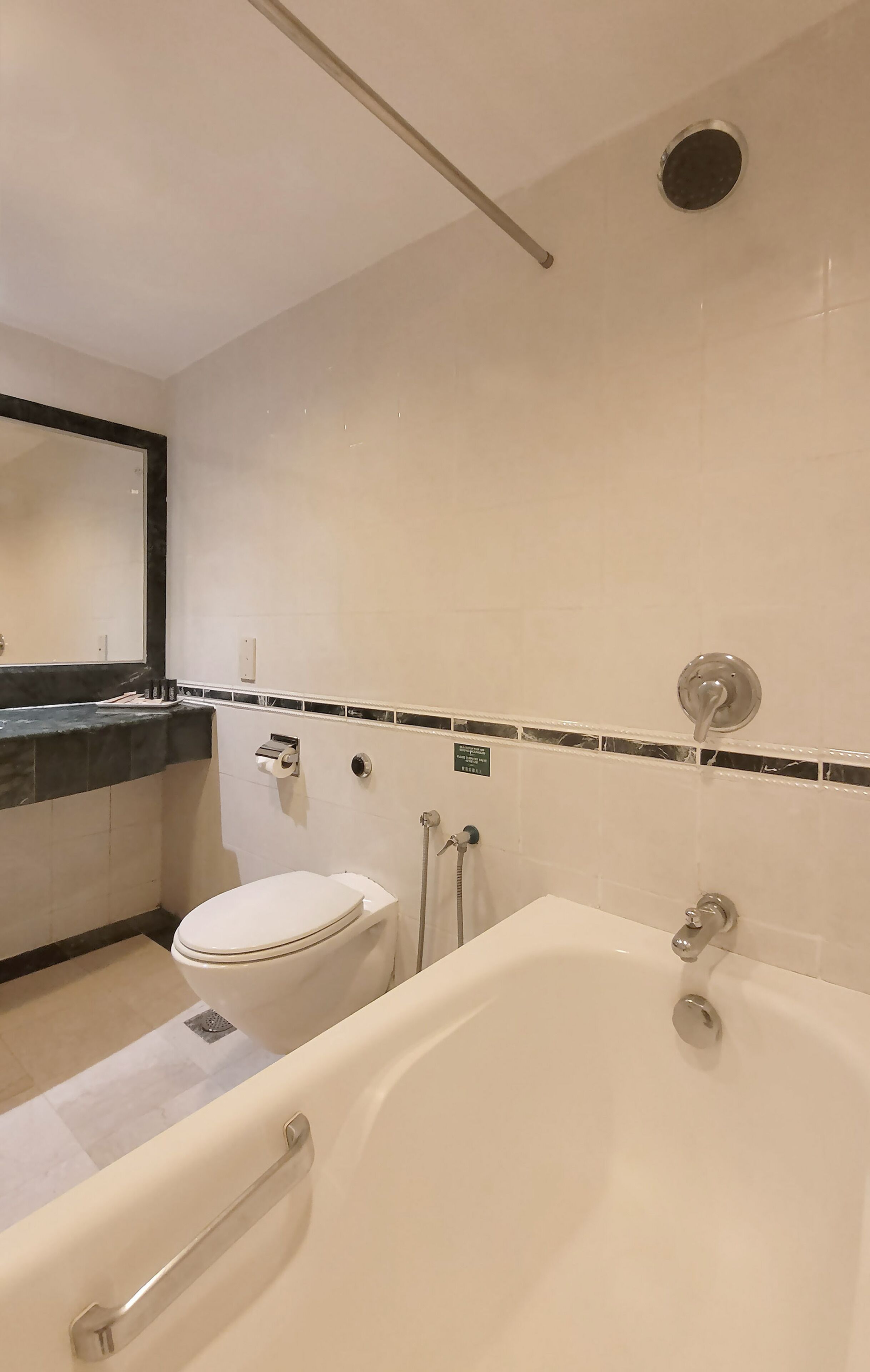 Un baño con bañera, inodoro y espejo.