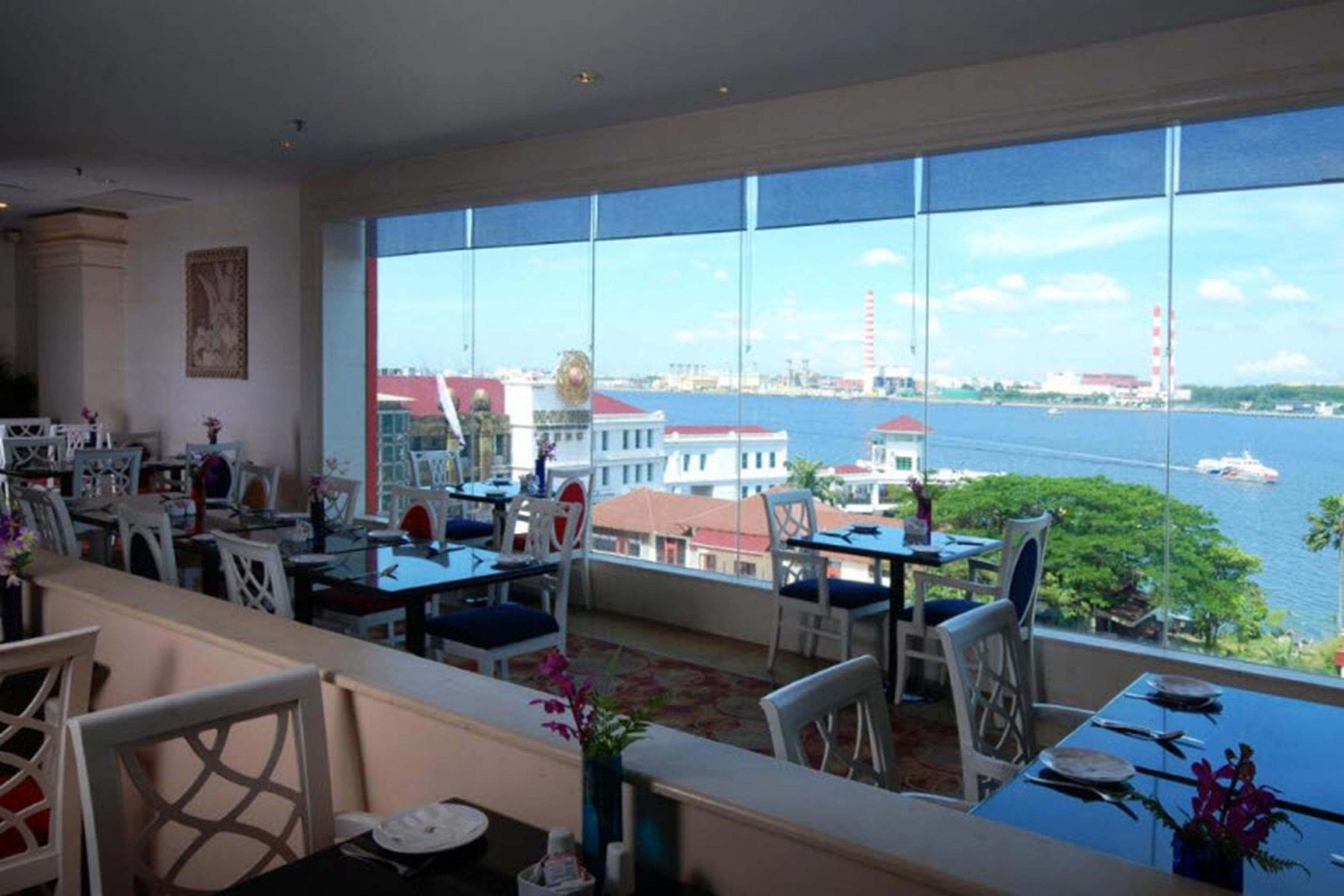A restaurant with a view of a body of water and buildings across the water.