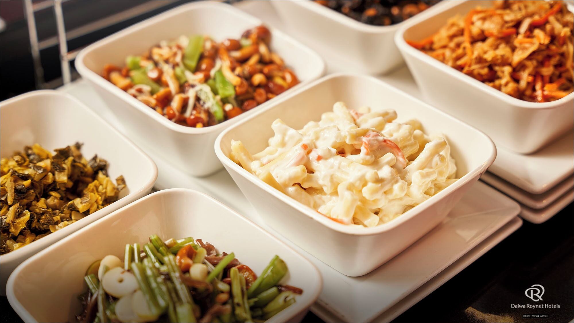 A buffet with various dishes including pasta, salad, and other prepared foods.