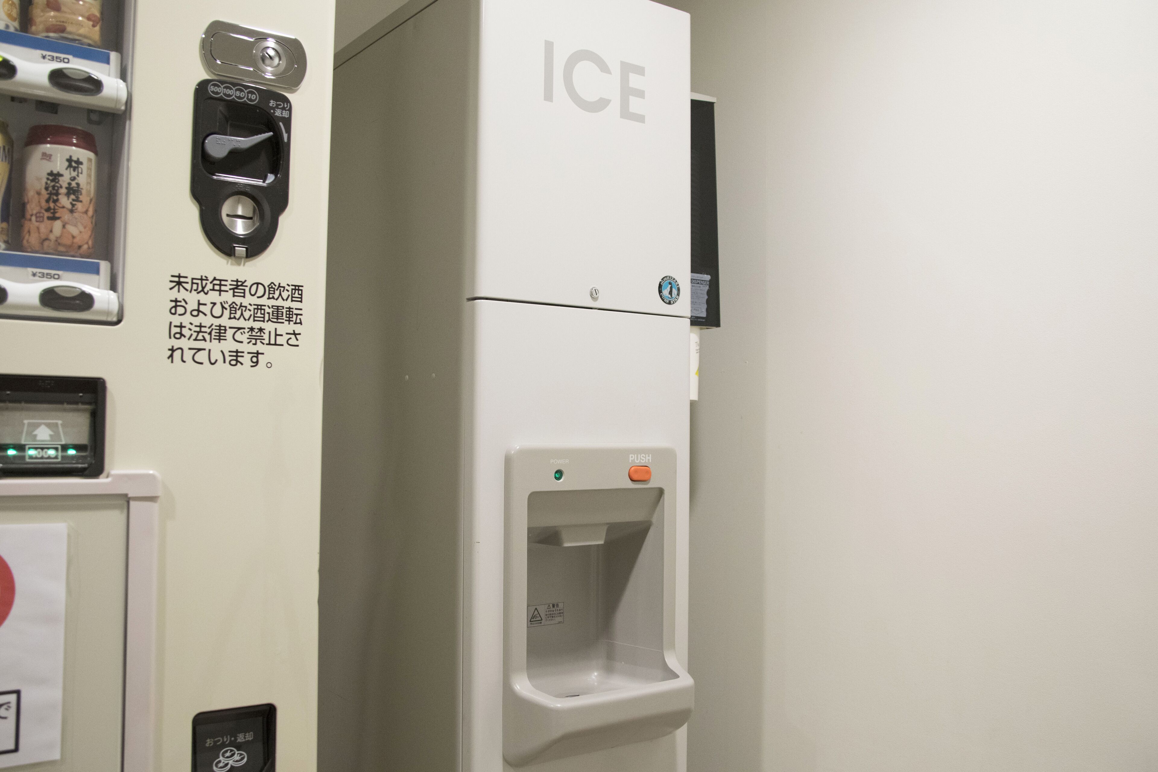 A vending machine with an 'ICE' label, a drink dispensing area, and a payment interface.