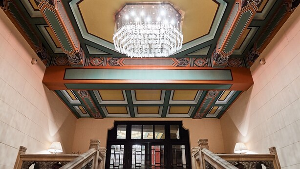 A grand staircase with ornate railings and a chandelier, leading to a door with intricate designs. - Jinjiang Metropolo Hotel Classiq, YMCA (Shanghai)