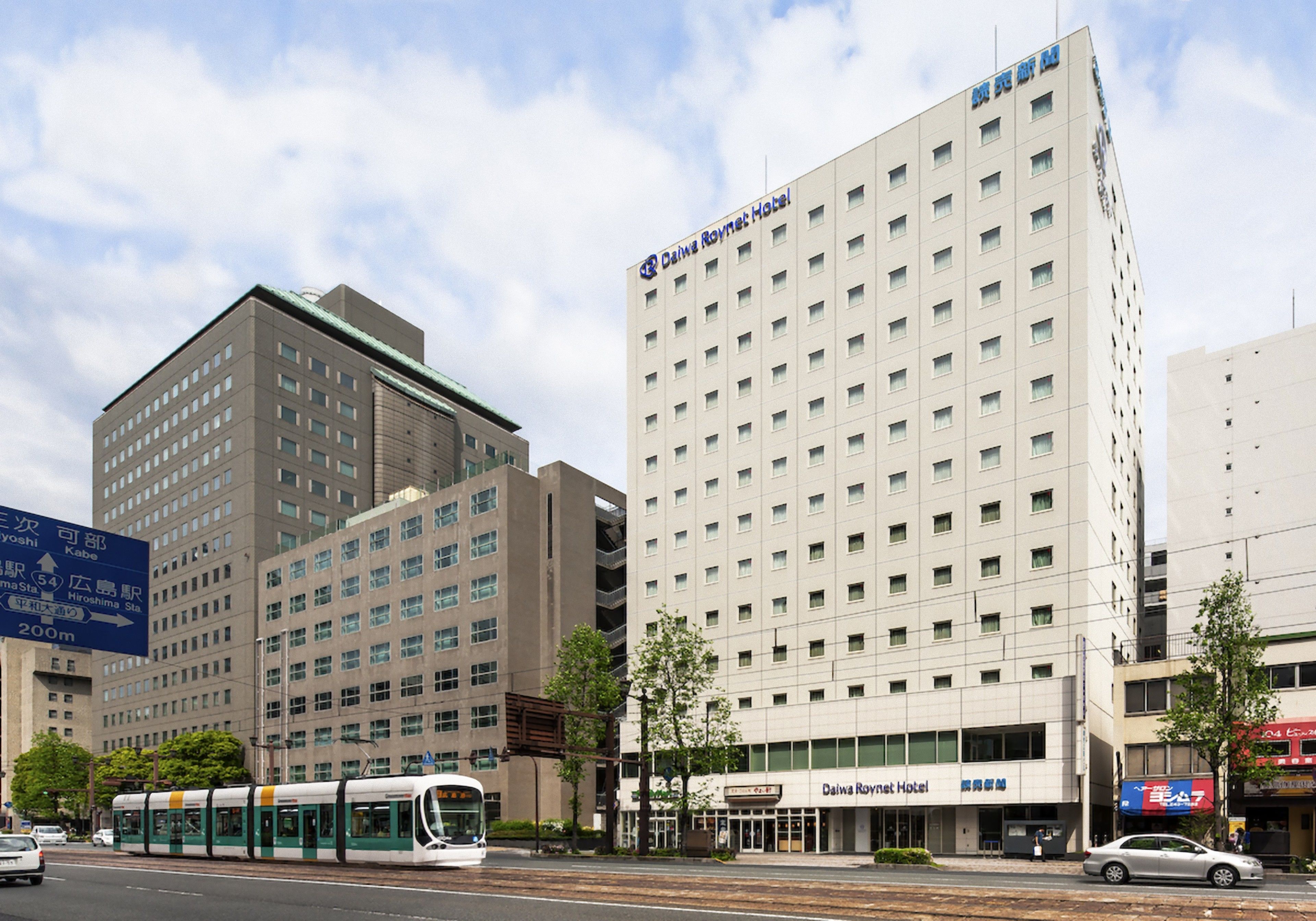 A hotel with a modern design, multiple floors, and a prominent sign.