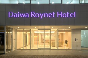 The Daiwa Roynet Hotel entrance with a glass facade and illuminated signage.