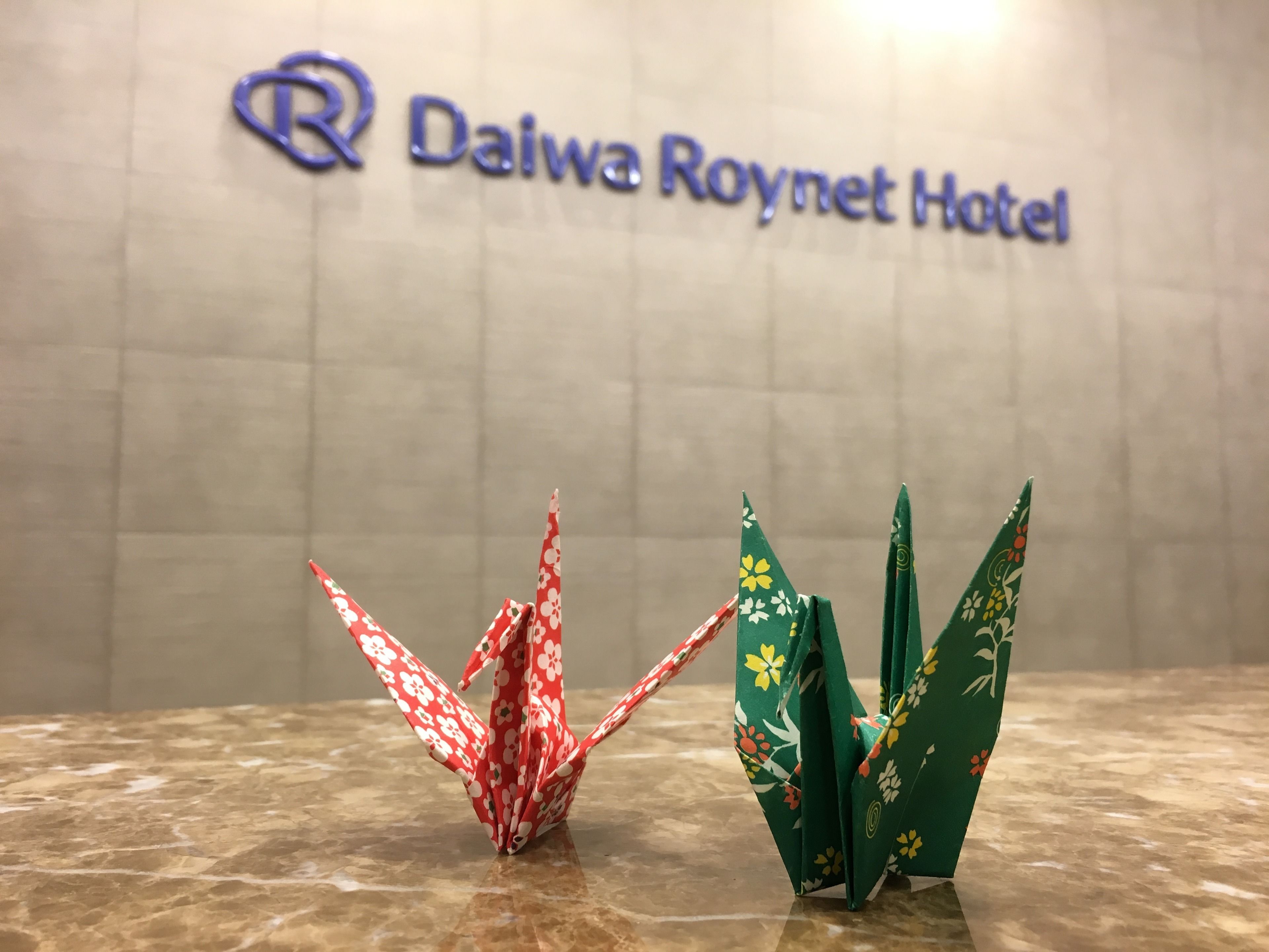 A sign for the Daiwa Roynet Hotel with origami decorations.