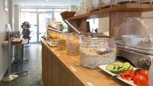 Un área de buffet con diferentes alimentos y utensilios.