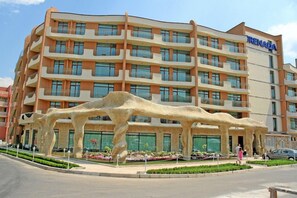 A multi-story hotel with a distinctive architectural design, featuring balconies and a central atrium. - Hotel Grenada - All Inclusive (Sunny Beach)