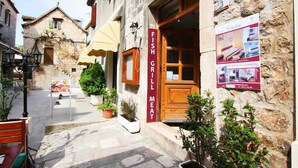 Un edificio de piedra con una puerta de madera que dice "FISH GRILL MEAT".