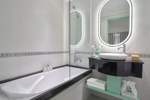 Une salle de bain moderne avec une baignoire, un meuble-lavabo et un grand miroir.