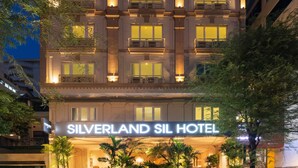 Un hôtel à plusieurs étages, doté de balcons, d’une entrée bien éclairée et d’une enseigne indiquant « Silverland SIL Hotel ».
